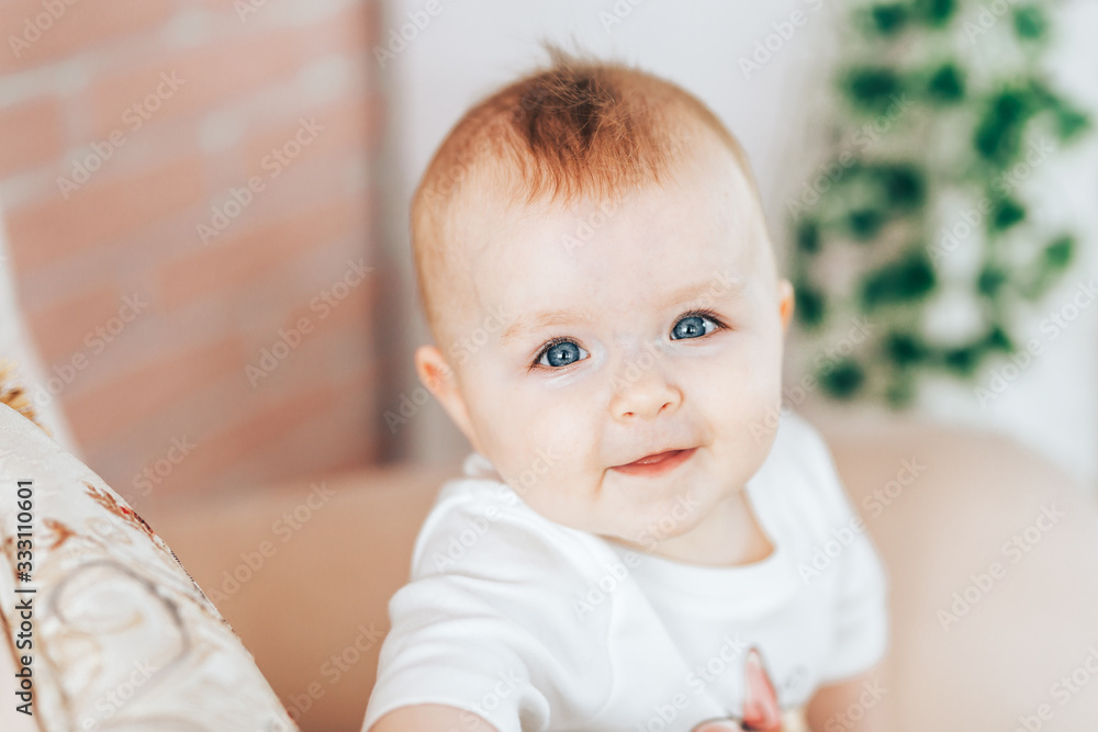 little very beautiful baby girl, looking at camera with beautiful blue eyes, cute baby sitting at home, light color interior. little very beautiful baby girl, looking at camera with beautiful blue eyes, cute baby sitting at home, light color interior.