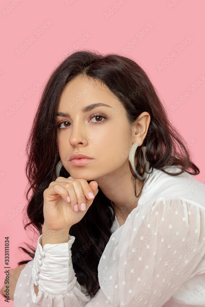 Young pretty brunette woman in a white blouse looking serious Young pretty brunette woman in a white blouse looking serious