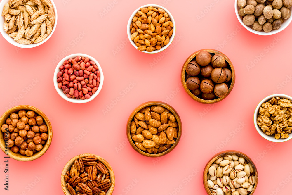 Set of macadamia, hazelnut, walnut, almond, pistachio, pecans nuts on pink background top-down pattern Set of macadamia, hazelnut, walnut, almond, pistachio, pecans nuts on pink background top-down pattern