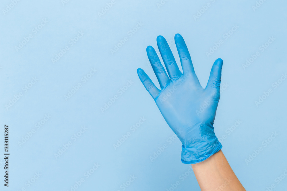 Obraz premium Doctor hand glove shows number five front on blue background.