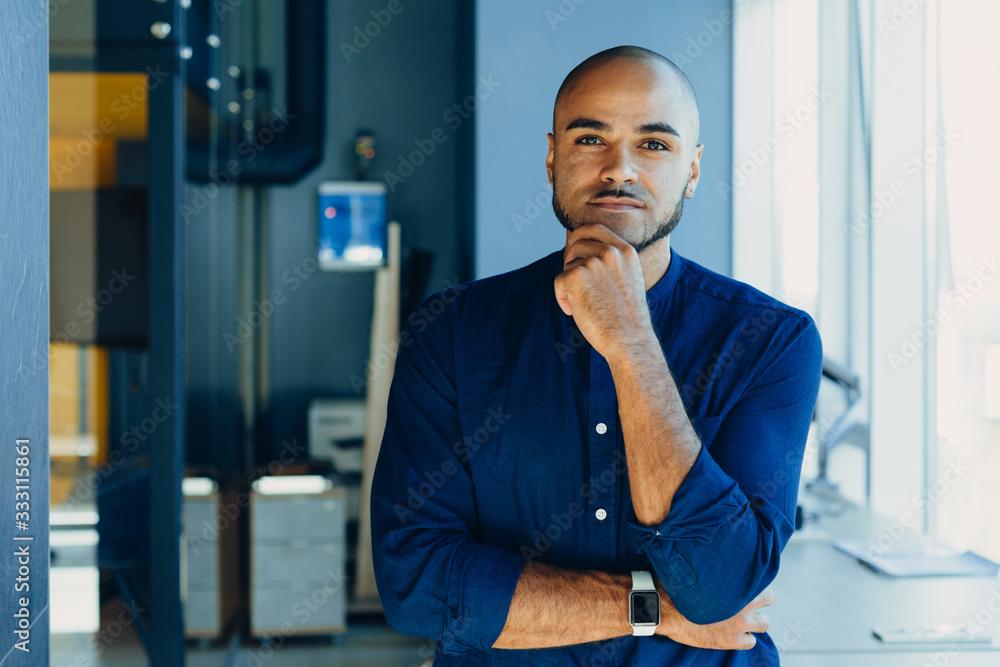 Happy african american businessman entrepreneur startup owner stand in modern office looking at camera, smiling young black designer creative  person posing in work space