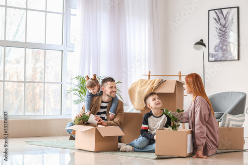 Family unpacking moving boxes in their new house