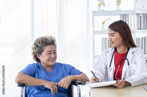 Tableau sur toile Young attractive Asian doctor is discussing to the patient about her symptoms, healtcare and hospital concept