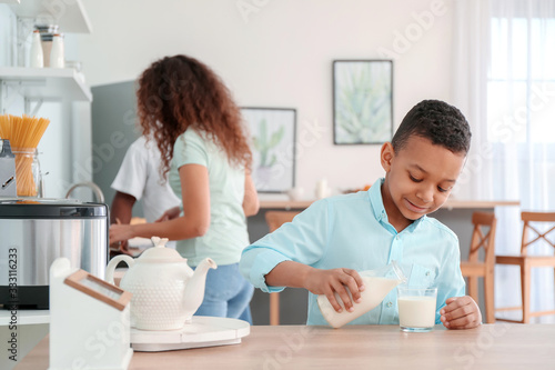 African-American boy drinking milk in kitchen