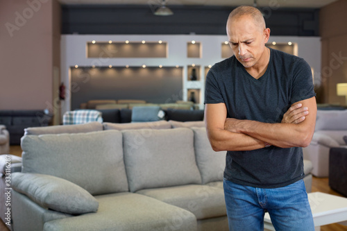 Portrait of male client in furniture salon shopping room with couches