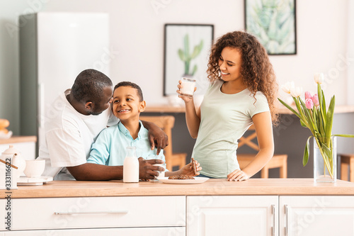 African-American family drinking milk in kitchen