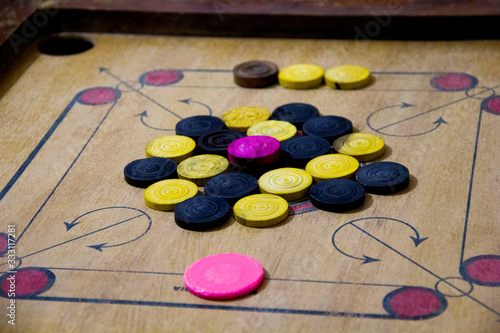 A game of carom set and ready to play. A game of carrom with pieces carrom man on the board carrom. Carom board game, selective focus.
