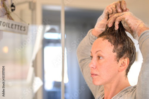 Woman running hair dye through to the tips photo