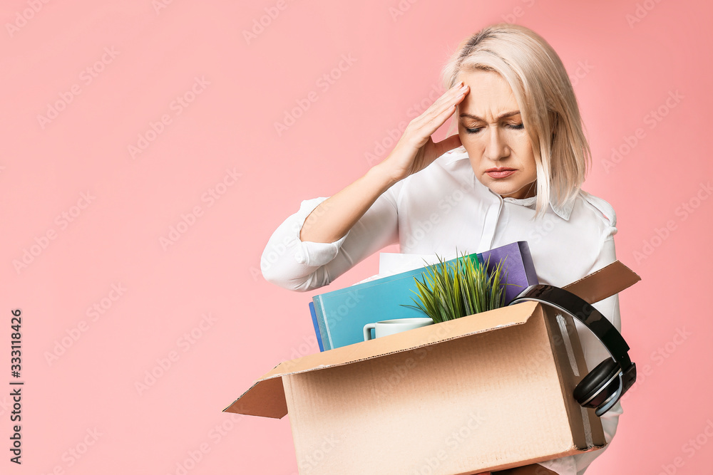 Sad fired mature woman with personal stuff on color background Sad fired mature woman with personal stuff on color background