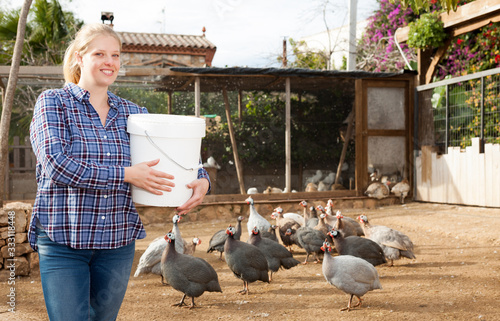 Woman feeding poultry photo