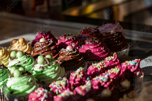 Muffins and cupcakes behind the glass in a cafe.