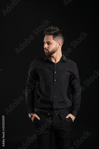 Handsome man with healthy hair on dark background