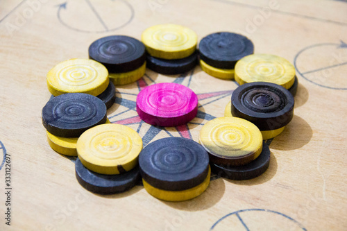 A game of carom set and ready to play. A game of carrom with pieces carrom man on the board carrom. Carom board game, selective focus.