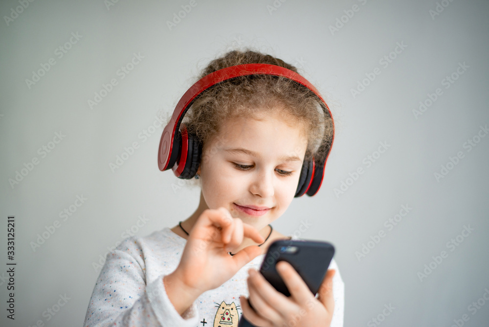 little girl in red headphones with a phone little girl in red headphones with a phone