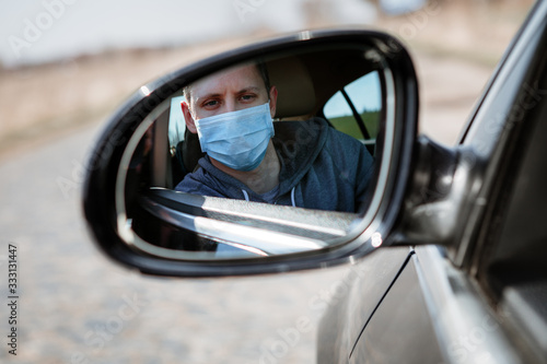 Man in the medical mask in car. coronavirus, disease, infection, quarantine, covid-19 © Ruslan Ivantsov