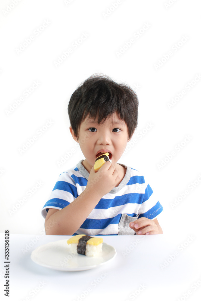 Portrait Of Little Asian Boy Eating Tamago Sushi Isolated On White Background Portrait Of Little Asian Boy Eating Tamago Sushi Isolated On White Background