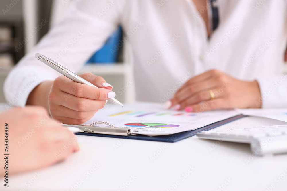 Female hand point silver pen to graph on seminar. Bank credit, loan money, invest, tax situation review, income calculation form, white collar train, investment audit, board members session concept Female hand point silver pen to graph on seminar. Bank credit, loan money, invest, tax situation review, income calculation form, white collar train, investment audit, board members session concept