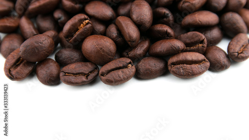 Dark coffee beans placed on a white scene.