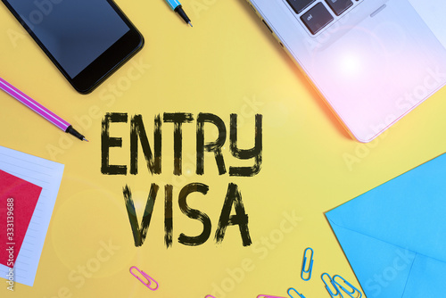 Conceptual hand writing showing Entry Visa. Concept meaning permission to enter a country of which you are not a national Laptop smartphone notepad markers sheet note clips colored back