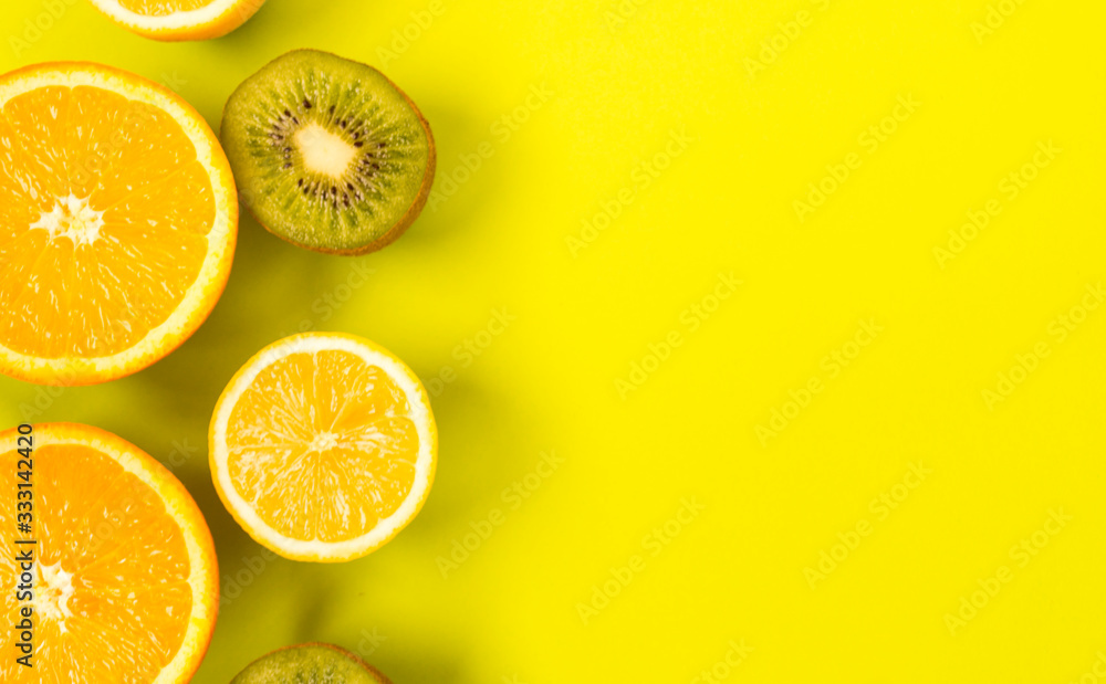 Fruit frame. Colorful fresh citrus fruits on a light green background. Orange, tangerine, lemon and kiwi are cut in half. Flat lay, top view, copy space. Fruit frame. Colorful fresh citrus fruits on a light green background. Orange, tangerine, lemon and kiwi are cut in half. Flat lay, top view, copy space.