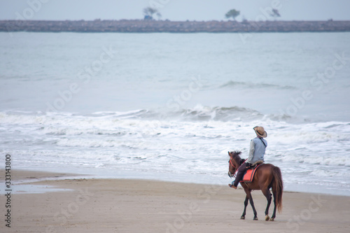 Woman riding a horse on the beach Background sea at Hua Hin Beach , Prachuap Khiri Khan in Thailand. March 15, 2020.