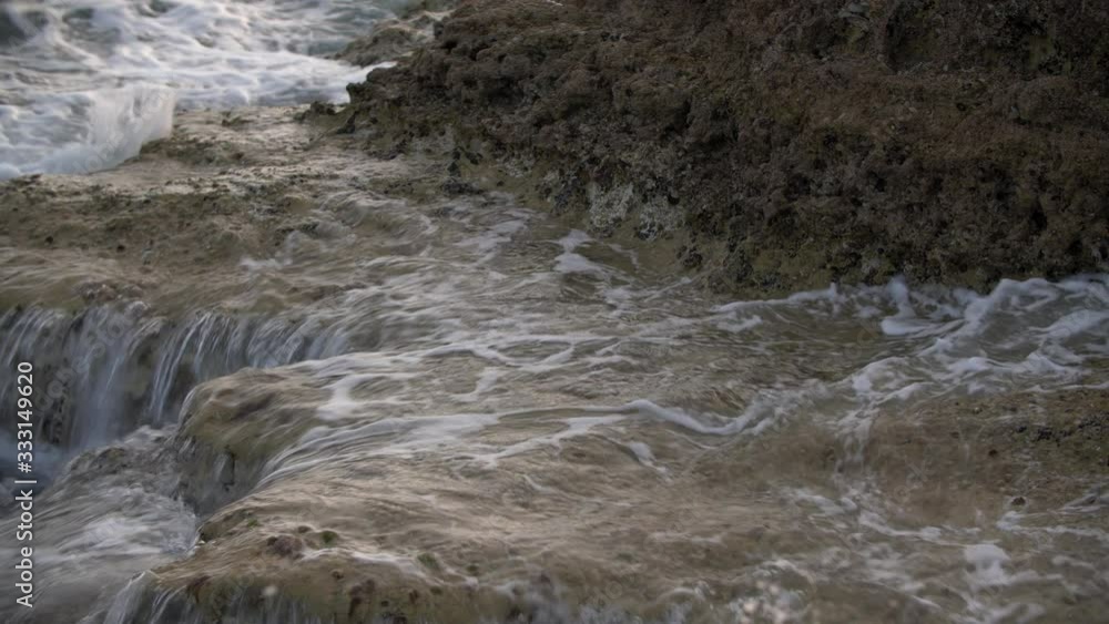 Slow motion waves rushing up onto rocks Slow motion waves rushing up onto rocks
