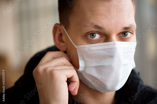 Portrait of a young guy wearing protection face mask against coronavirus.
