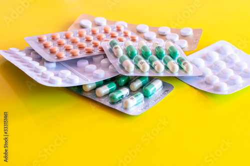 Six blisters of generic tablets on yellow background.Pills in packages.Various medications.Stockpiling medicines.Mental health issue.Depression treatment. photo