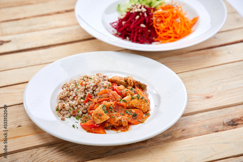 meat with buckwheat and salad on the wooden background meat with buckwheat and salad on the wooden background