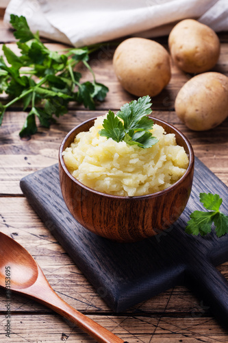 Homemade cream mashed potatoes in a dish with parsley. photo