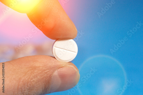 tablet pill in hand close-up selective focus. concept of medicine, medicine. on a blue background.