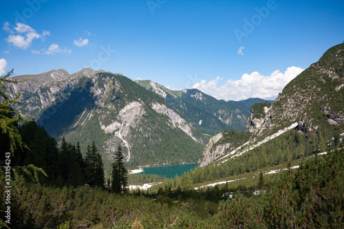 Panorama of Braies Lake in Dolomites mountains, Alps mountain chain, Trentino Alto Adige region, Sudtirol, Italy. Beautiful Alpine lake Lago di Braies in sunny day