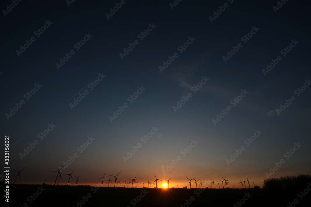 Windturbinen an der Nordseeküste bei Sonnenuntergang Windturbinen an der Nordseeküste bei Sonnenuntergang