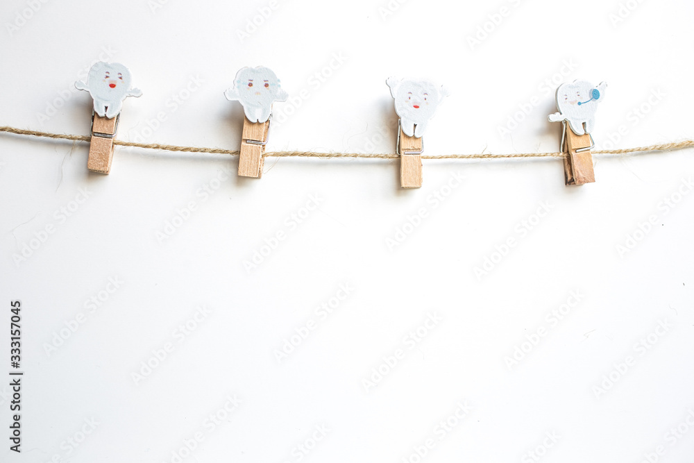 Clothes pegs with wooden teeth on a clothesline rope isolated on white background. Clothes pegs with wooden teeth on a clothesline rope isolated on white background.