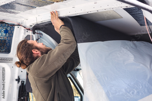 Man working on insulating his camper van