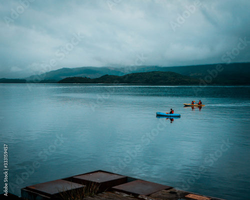 Two Kayaks on a peaceful serene lake in Luss, Scotland. overcast, cloudy day with calm water. Recreational activities. 