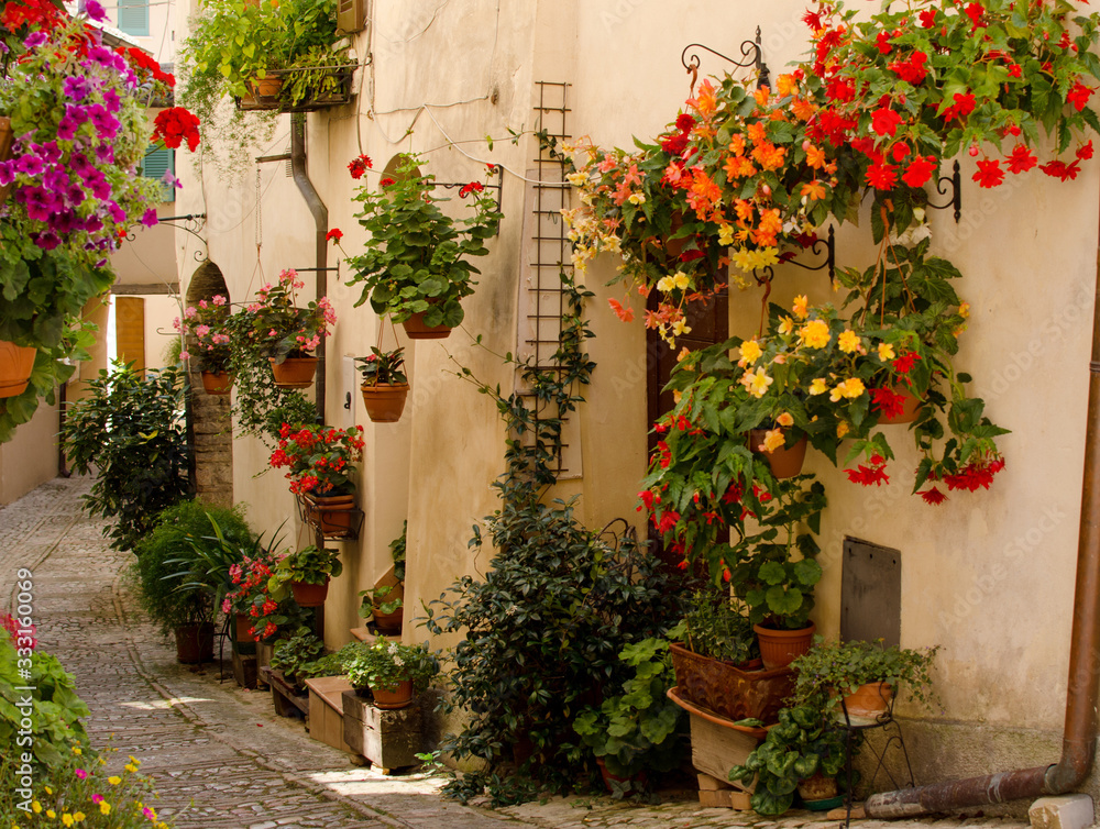 Medieval street of Spello decorated with flowers, Italy