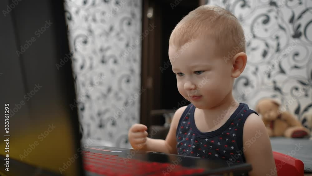 Charming genius kid 2 years old writes words on his laptop. Charming genius kid 2 years old writes words on his laptop.