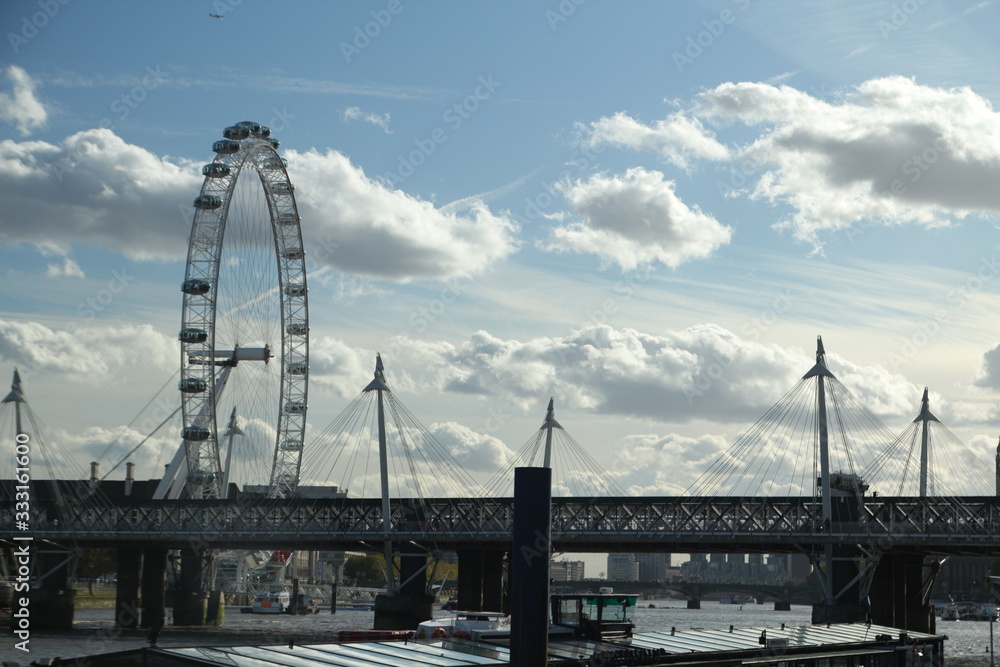 London Hungerford bridge and London Eye blue sky with fluffy clouds