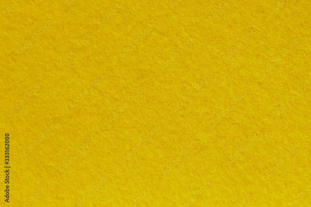 Obraz premium Yellow felt background. Surface of fabric texture.