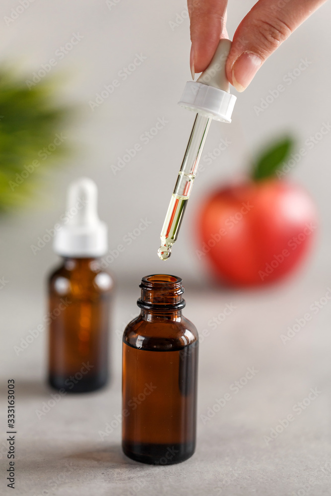 A female hand holds a dropper from a dropper bottle. Beauty concept. Natural oils. Spa care. A female hand holds a dropper from a dropper bottle. Beauty concept. Natural oils. Spa care.