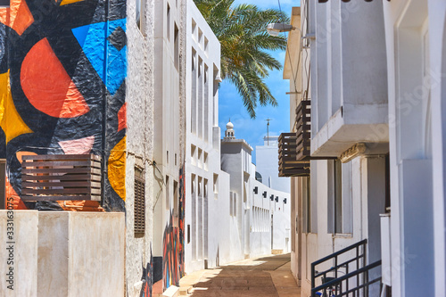 фотографія Narrow street with traditional white houses in the old district in Bahrain