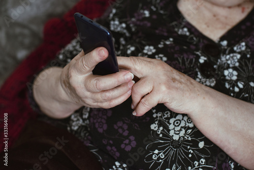 Beautiful hands of a old woman. Old woman's hands with wrinkles touching screen her smartphone