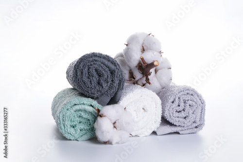 Bath accessories. Hygiene products. Multi-colored bath towels with a flower of cotton on a white background. © VI Studio
