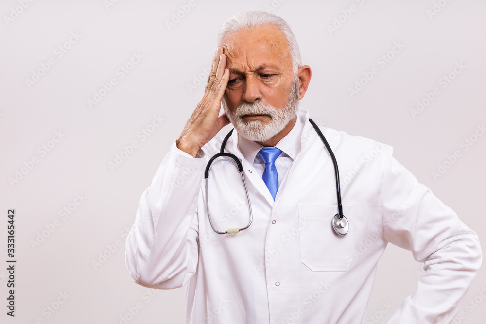 Image of tired senior doctor having headache on gray background. Image of tired senior doctor having headache on gray background.