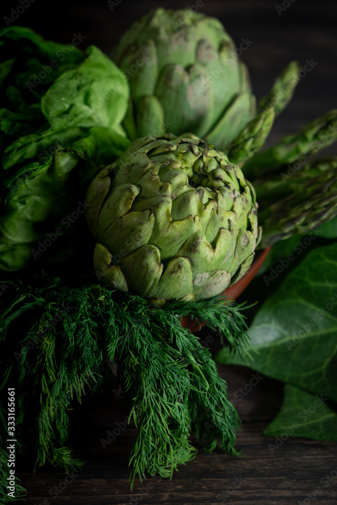 Obraz premium Artichokes, herbs, salt and pepper on wooden table