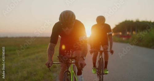 Two Male cyclist biking at sunset