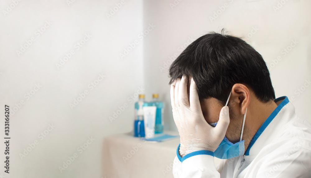 Naklejka premium The doctor sad and depressed having stress breakdown in a white room at spread corona virus time with copy space,Covid-19.