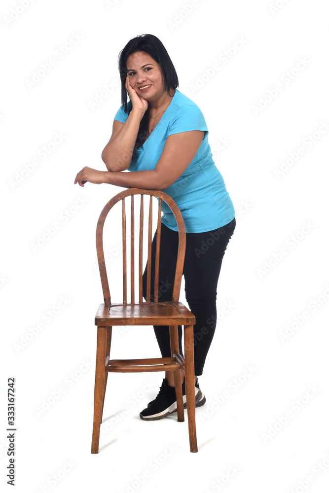 Fototapeta premium woman playing with a chair in white background, leaning on the chair