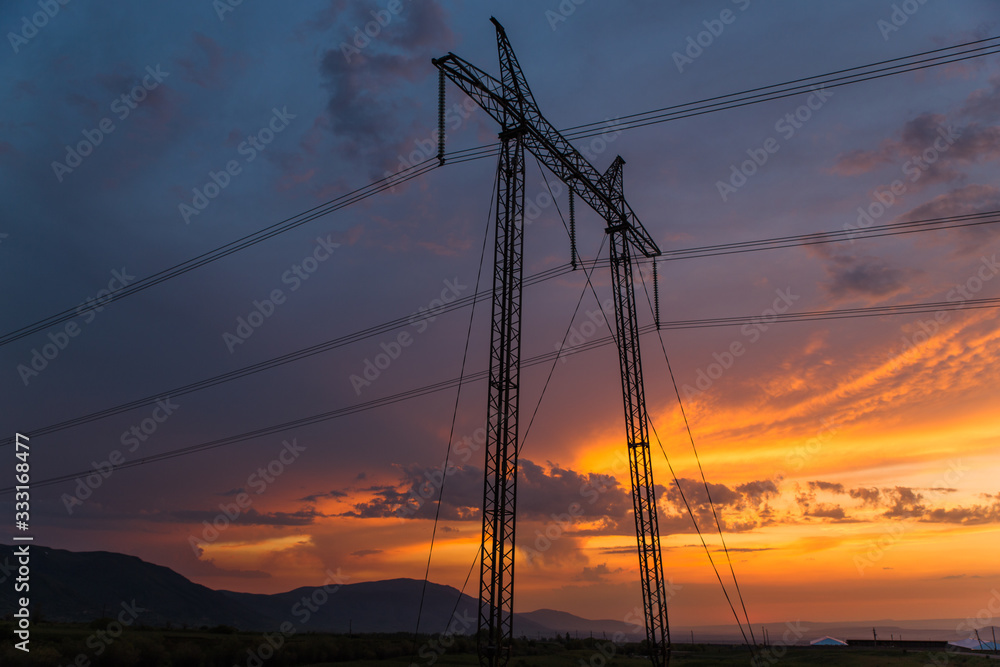 transmission lines silhouette and amazing sunset in Aksu Zhabagly nature reserve, oldest in Central Asia, situated in Kazakhstan